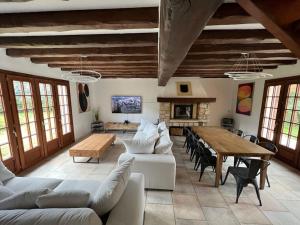 a living room with a table and a dining room at La clé des champs - Les Grais 1H10 de Paris in Bazoches-sur-le-Betz