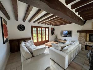 a living room with two white couches and a fireplace at La clé des champs - Les Grais 1H10 de Paris in Bazoches-sur-le-Betz