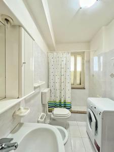 La salle de bains blanche est pourvue d'un lavabo et de toilettes. dans l'établissement Villa D'Agati, à San Giorgio