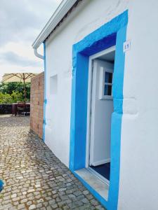 um edifício azul e branco com uma porta em Casas do Tareco em Biscoitos