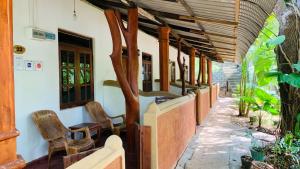 una fila de sillas sentadas a un lado de un edificio en Sisira Natural Lodge - Sigiriya, en Sigiriya