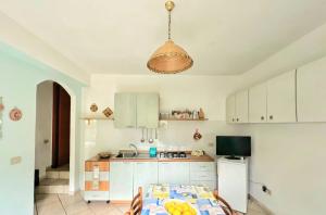 een keuken met witte kasten en een tafel in een kamer bij Villa D'Agati in San Giorgio