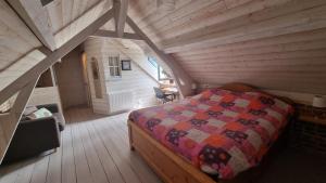 サン・ヴァレリー・シュル・ソンムにあるMaisonnette à Saint Valéry Sur Sommeの木造キャビン内のベッド1台が備わるベッドルーム1室を利用します。