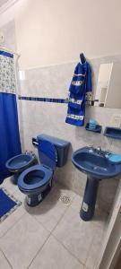 uma casa de banho com um WC azul e um lavatório. em Casa blanca Posadas em Posadas