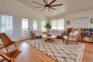 a living room with chairs and a ceiling fan at Carolina Sunshine in Holden Beach