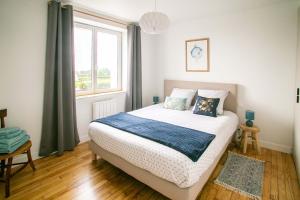 um quarto com uma cama e uma janela em Ty Meham, à 700m de la plage et Meneham, grand terrain calme em Kerlouan