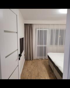 una camera da letto con un letto e una finestra di Hermann Apartment a Cluj-Napoca