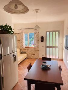 uma cozinha com uma mesa e um frigorífico num quarto em Le Maioliche em Saponara Villafranca