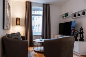 a living room with two chairs and a table and a television at Refugium mit Stil I Nähe HBF und Innenstadt in Hannover