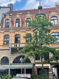 un grande edificio in mattoni con un albero di fronte di Refugium mit Stil I Nähe HBF und Innenstadt ad Hannover