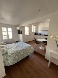 a bedroom with a bed and a table and a kitchen at Saint-Tropez Centre - Grand Studio avec terrasse in Saint-Tropez