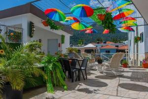 a patio with a table and chairs with colorful umbrellas at Royal Terrace III (Prince) in San Felipe de Puerto Plata