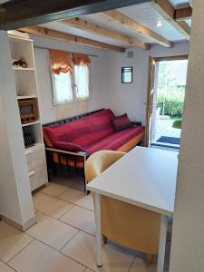 una camera con un divano rosso di "Les Echalas" Appartement indépendant avec cuisine en Lavaux Unesco a Chexbres