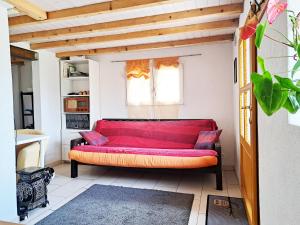un divano rosso in una stanza con finestra di "Les Echalas" Appartement indépendant avec cuisine en Lavaux Unesco a Chexbres