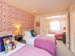 a bedroom with two beds and a brick wall at Pass the Keys Luxury City Centre House in Bath