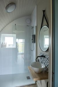 een badkamer met een wastafel en een spiegel bij Glengolly Getaways in Thurso