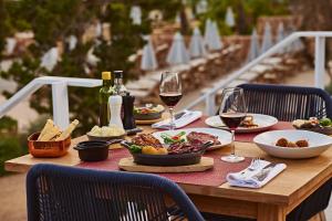 a wooden table with food and glasses of wine at TRS Ibiza Hotel - Adults Only in San Antonio