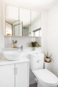 een badkamer met een toilet, een wastafel en een spiegel bij Earth & Heavens in Kinneret