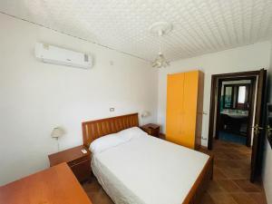 een slaapkamer met een bed, een tafel en een bureau bij Le Maioliche in Saponara Villafranca