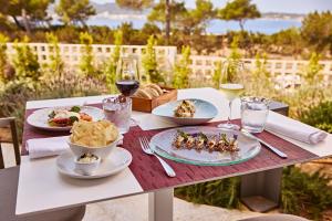 a table with plates of food and glasses of wine at TRS Ibiza Hotel - Adults Only in San Antonio