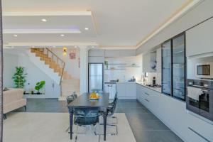 卡爾坎的住宿－Hadi Villa，厨房、带桌子的客厅和用餐室