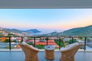 a balcony with chairs and a view of a city at Hadi Villa in Kalkan