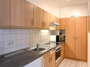 a kitchen with wooden cabinets and a sink at Dünenblick Wohnung 36 in Boltenhagen