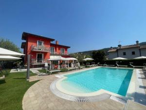 een groot zwembad voor een rood gebouw bij G&G Bed&Breakfast and apartments in Garda