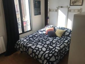 a bedroom with a black and white bed with pillows at Porte de Paris - Saint-Denis quartier historique in Saint-Denis