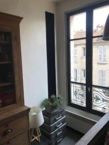 a room with a window and a dresser with a plant at Porte de Paris - Saint-Denis quartier historique in Saint-Denis