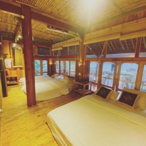 a bedroom with two beds in a room with windows at Jack Ecolodge in Lung Co (1)