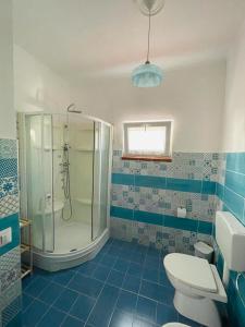 een blauwe en witte badkamer met een douche en een toilet bij Le Maioliche in Saponara Villafranca