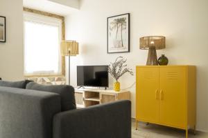 sala de estar con armario amarillo y TV en Seixal Bay Apartments en Arrentela