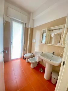 baño con 2 aseos, lavamanos y lavamanos en Hotel Meeting, en Stresa