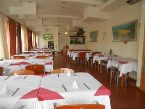 a dining room with white tables and chairs at Areia Dourada in Porto Santo