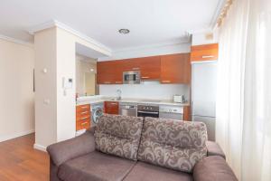 sala de estar con sofá y cocina en Apartamentos Verdemar (VUT), en Llanes