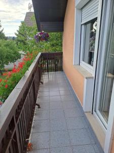 a balcony of a house with flowers and a window at Apartmaji Peric in Ljubljana