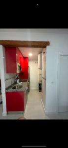 グラナダにあるDuplex en el centro de granadaのキッチン(赤いキャビネット、シンク付)