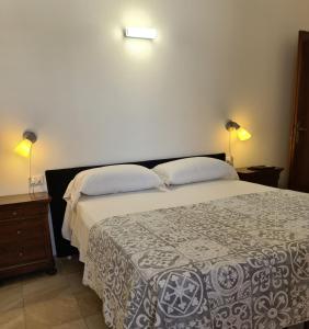 a bedroom with a large bed with two lamps on it at Camere al Mare in Lido di Camaiore