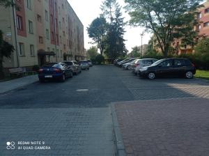 um parque de estacionamento com carros estacionados ao lado de uma rua em Apartament na parterze em Stalowa Wola