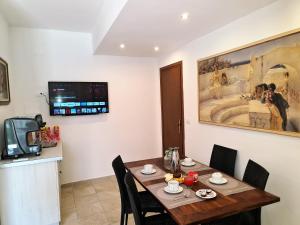 a dining room with a table with chairs and a tv at Camere al Mare in Lido di Camaiore