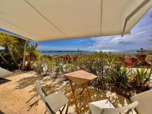 une terrasse avec une table et des chaises et l'océan dans l'établissement Loft Marina direct plage, à Villeneuve-Loubet