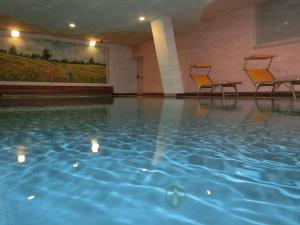 una piscina con 2 sillas en un edificio en Beauty & Vital Hotel Maria, en Carano