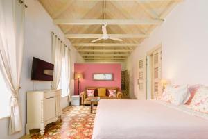 a bedroom with a white bed and a couch at Villa Tokara Boutique Hotel in Willemstad