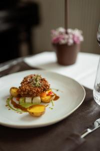 a white plate with food on a table at Hotel Europa Splendid in Merano