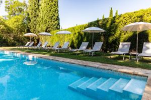 a group of chairs and umbrellas next to a swimming pool at La Magdeleine - Mathias Dandine in Gémenos
