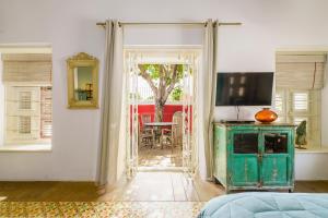 Zimmer mit einer Tür, die auf eine Terrasse mit einem Tisch führt. in der Unterkunft Villa Tokara Boutique Hotel in Willemstad