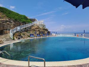 una piscina con sillas y el océano en el fondo en Capo d'Arco la Terrazza - Goelba en Capo D'Arco