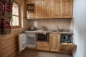 una piccola cucina con armadi in legno e lavandino di Chalet Camping Faè 2 a Madonna di Campiglio