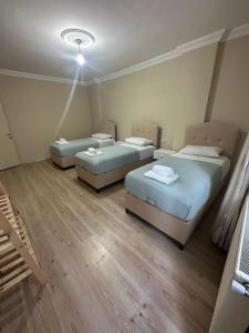 3 camas num quarto com pisos em madeira em Cosy house best location em Yomra